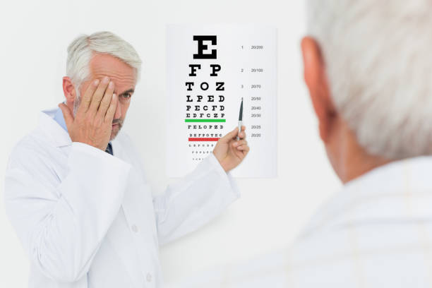 istock Pediatrician ophthalmologist with senior patient pointing at eye chart 693106320