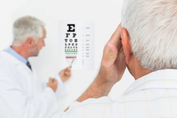 istock Pediatrician ophthalmologist with senior patient pointing at eye chart 693106356