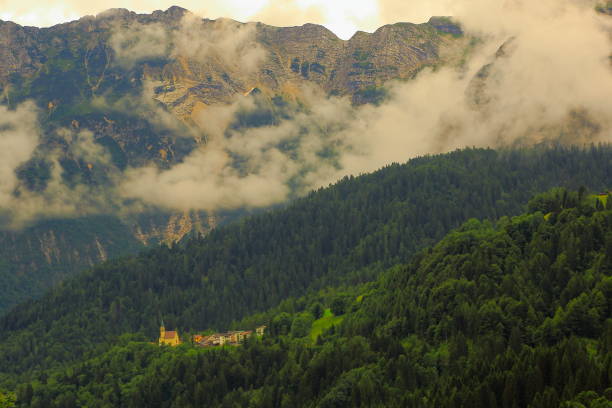 istock Alpine Church between mist and clouds - Idyllic pinnacles mountain range , dramatic panorama and majestic Dolomites, Italy tirol alps 693106370