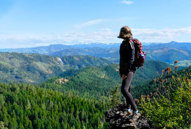 Woman hiker on mountain top looking at view.