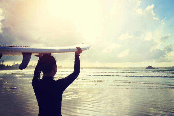 istock young woman surfer with surfboard ready to surf on a beach 693125912