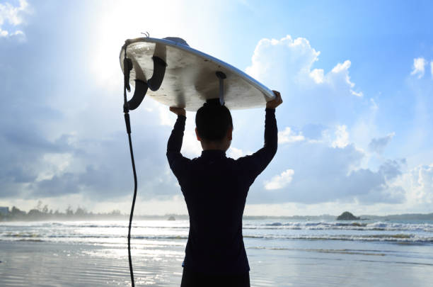 istock young woman surfer with surfboard ready to surf on a beach 693128894