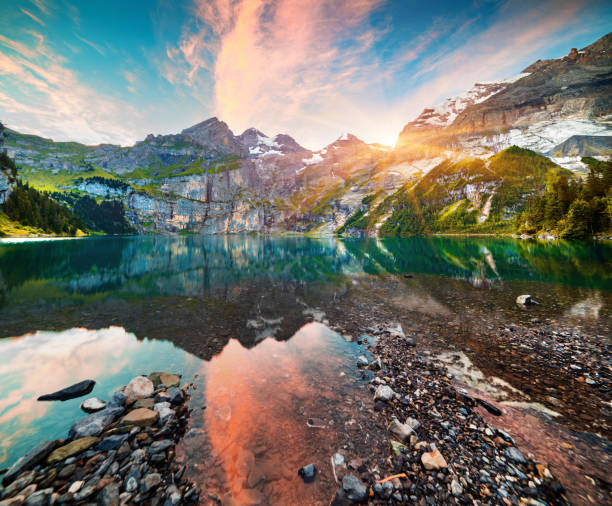 Colorful summer morning on unique lake - Oeschinen (Oeschinensee) Colorful summer morning on unique lake - Oeschinen (Oeschinensee), UNESCO World Heritage Site. Beautiful outdoor scene in Bernese Oberland Alps, Switzerland, Europe. lake oeschinensee stock pictures, royalty-free photos & images
