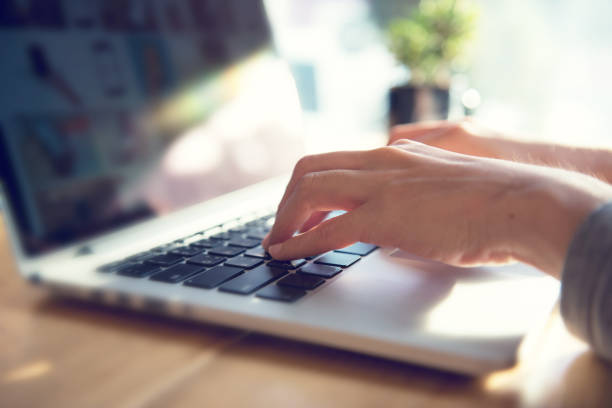 Closeup woman's hands typing on a laptop