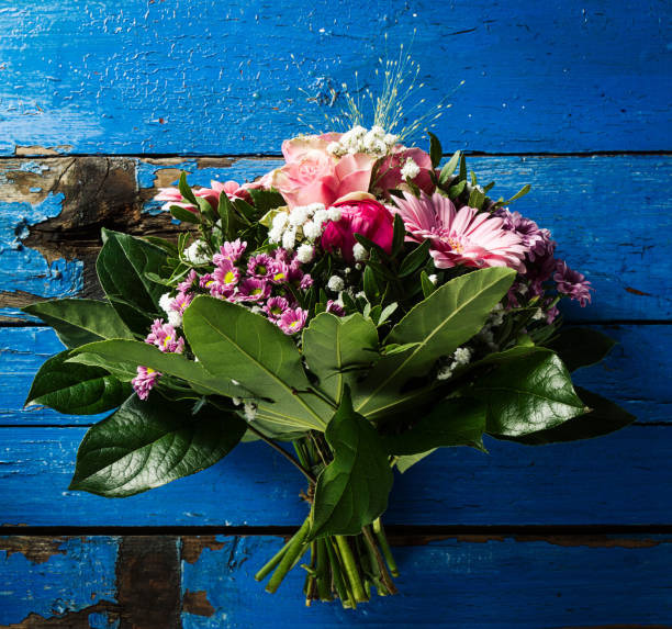 istock Beautifu pastel colors bouquet on blue rustic old table. Top View. 693171136
