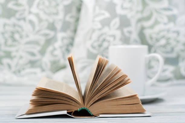istock Open hardback book, cup on wooden table. natural background . Back to school. Copy space for text 693171256