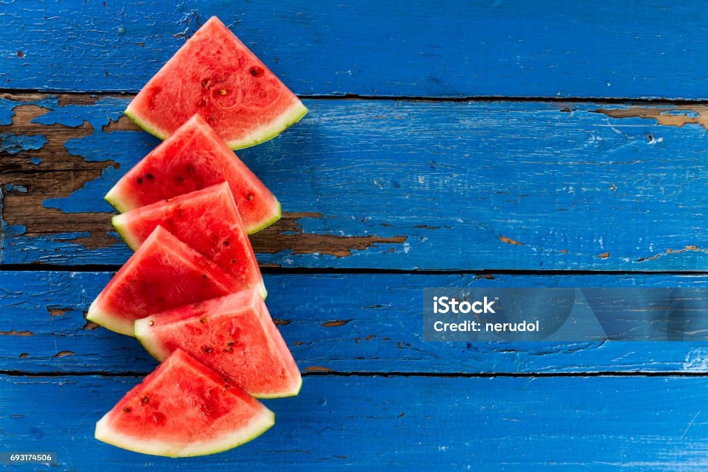 Sliced watermelon Top View. Many slices on an old rustic blue table. Side composition with copy space. Food Backrgound. Melon Stock Photo