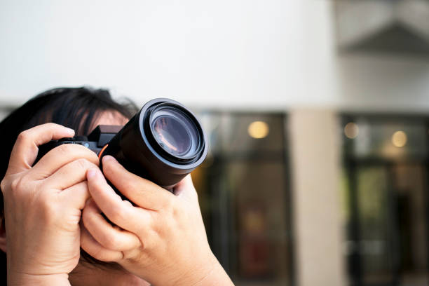 photographer holding camera - reportage photographer photographing street imagens e fotografias de stock