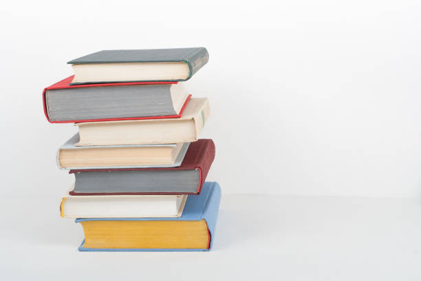 istock Book stacking. Open book, hardback books on wooden table and white background. Back to school. Copy space for text 693175542