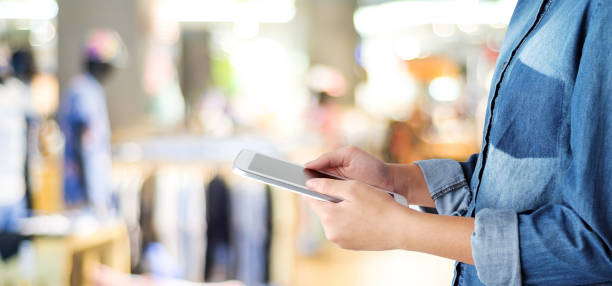 istock Hand using tablet over blur store with bokeh light background, banner, business and technology concept, digital marketing, seo, e-commerce 693192978