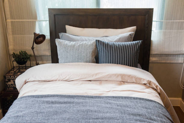 istock Many pillows on the bed and the bed head lamps with warm light. 693196000