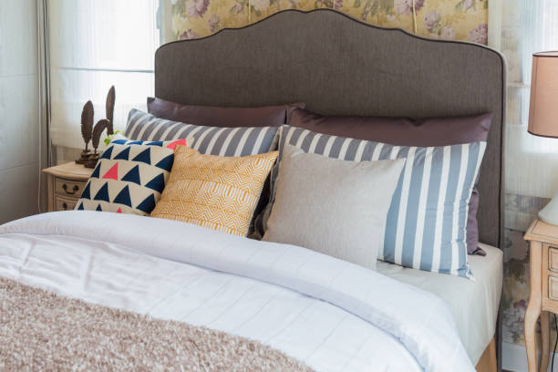 istock Many pillows on the bed and the bed head lamps with warm light. 693196154