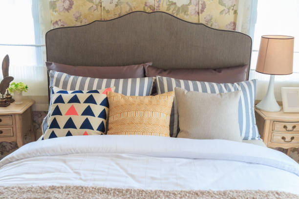 istock Many pillows on the bed and the bed head lamps with warm light. 693196366