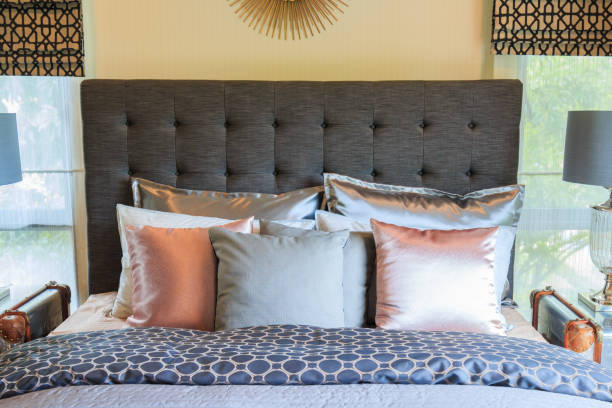 istock Many pillows on the bed and the bed head lamps with warm light. 693196502