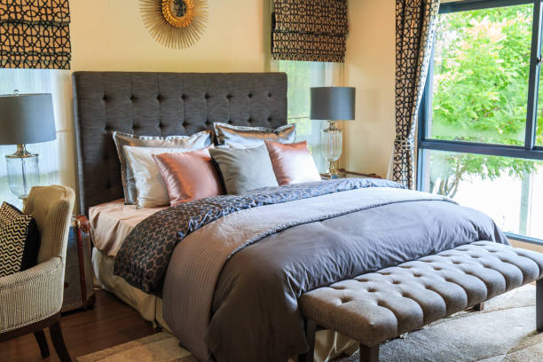 Many pillows on the bed and the bed head lamps with warm light.