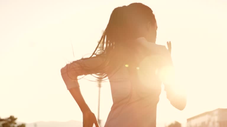 SLO MO TS African-American woman with long braided hair running in sunny stadium with sunset flares