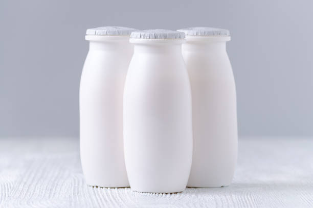tomar yogurt en botellas de plástico sobre fondo gris - inulin fotografías e imágenes de stock