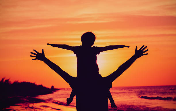 istock father and little son play on sunset beach 693208460
