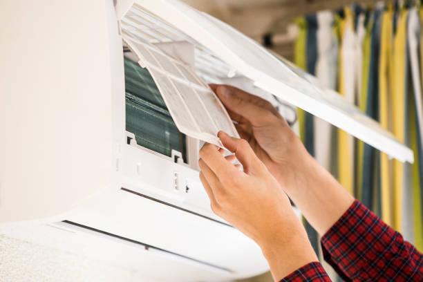 istock Man installs or repairs an air conditioner. 693210478