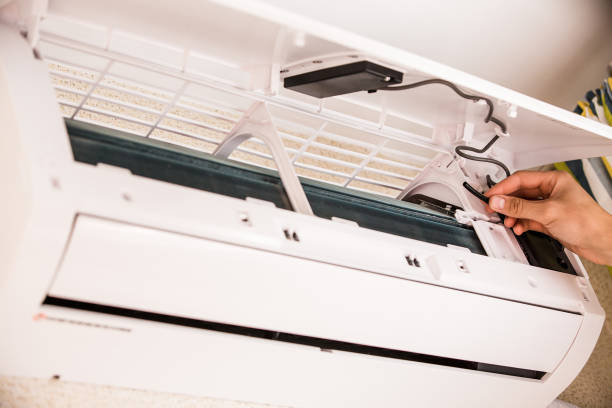istock Man installs or repairs an air conditioner. 693215042