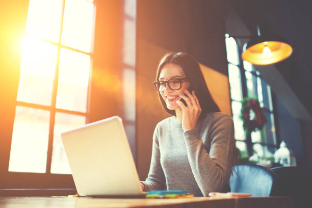 Cheerful attractive hipster girl having phone conversation with service manager