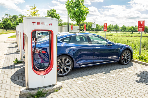 Tesla Model S electric car at a supercharger charging station. Superchargers are free connectors that charge Model S in minutes. Superchargers are used for long distance travel, located along the most popular routes in North America, Europe and Asia.