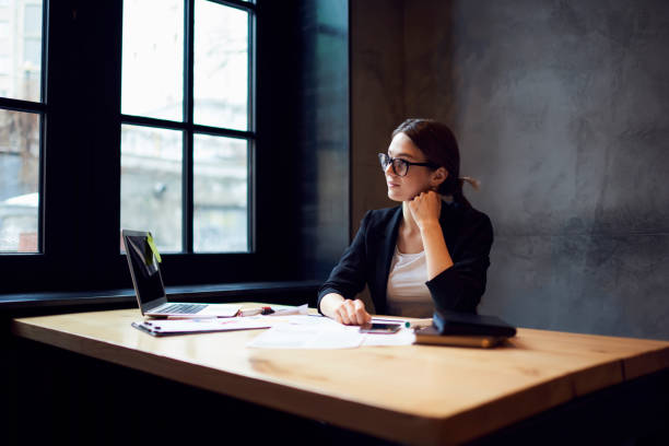 istock Pensive young attractive female graphic designer sitting at table 693215634