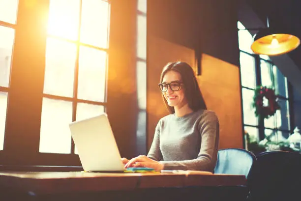 Photo of Smiling attractive female journalist browsing information making researchers for reportage