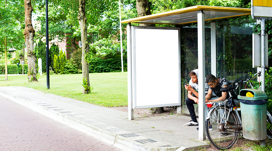 rural scene busstop abri or billboard poster mockup with young people hanging around waiting for the bus