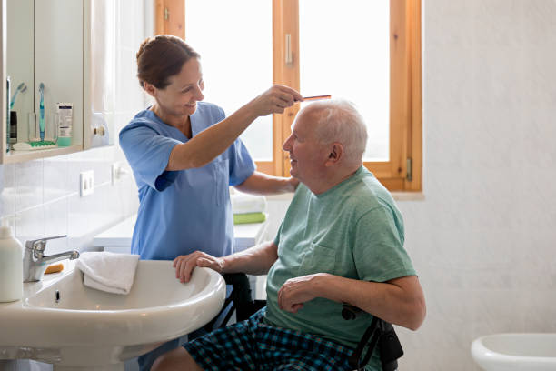 главная воспитатель со старшим человеком в ванной комнате - senior adult home caregiver help care стоковые фото и изображения