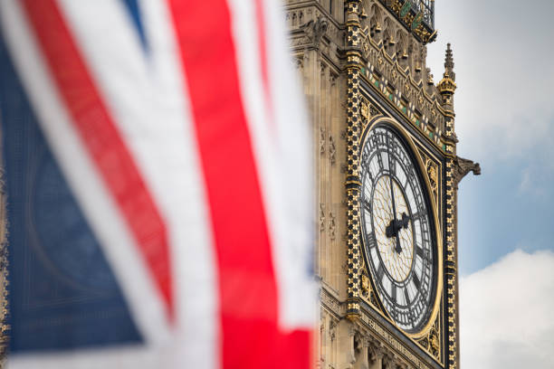 Union Jack fluttering in the wind with Big Ben in the background Union Jack fluttering in the wind with Big Ben in the background big ben stock pictures, royalty-free photos & images