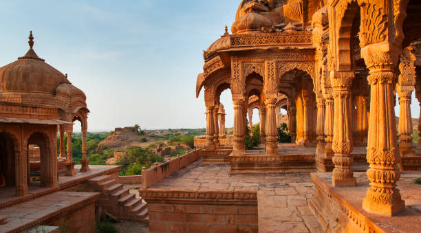 the royal cenotaphs of historic rulers, also known as jaisalmer chhatris, at bada bagh in jaisalmer, rajasthan, india. cenotaphs made of yellow sandstone at sunset - jaisalmer imagens e fotografias de stock