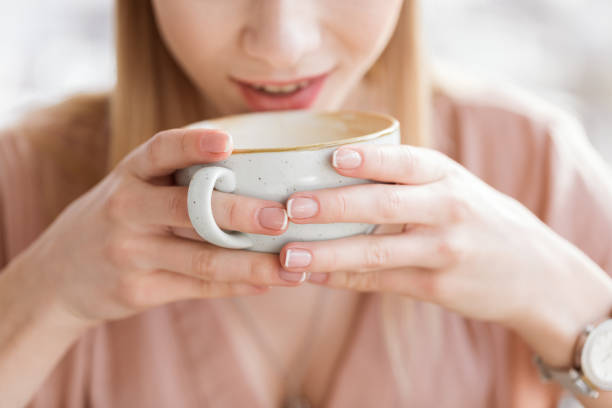 istock close up view of woman drinking coffee from big cup 693247848