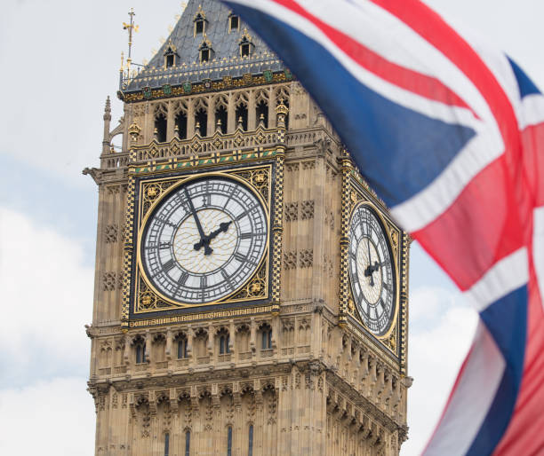 istock Union Jack fluttering in the wind with Big Ben in the background 693247918