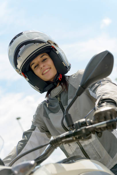 istock girl sits on a motorcycle and has a helmet on his head 693248714