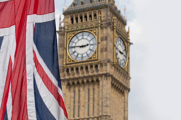 istock Union Jack fluttering in the wind with Big Ben in the background 693251602