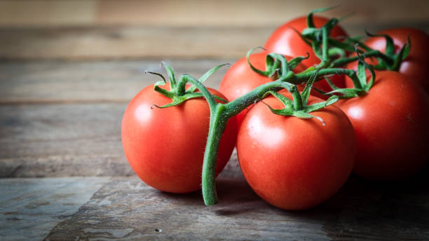 istock Fresh red tomatoes on a wooden background 693254430