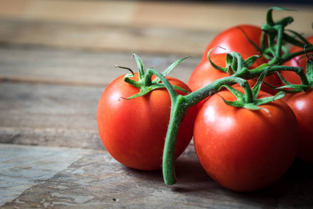 istock Whole red tomatoes on a wooden background 693254546