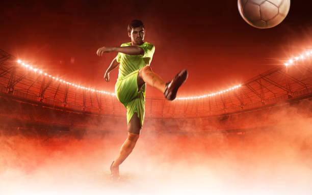 istock Soccer player hits a soccer ball on red background 693254668
