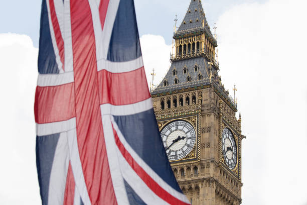 istock Union Jack fluttering in the wind with Big Ben in the background 693254686