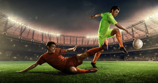 futbolistas peleando por una pelota en un campo - competición de fútbol fotografías e imágenes de stock