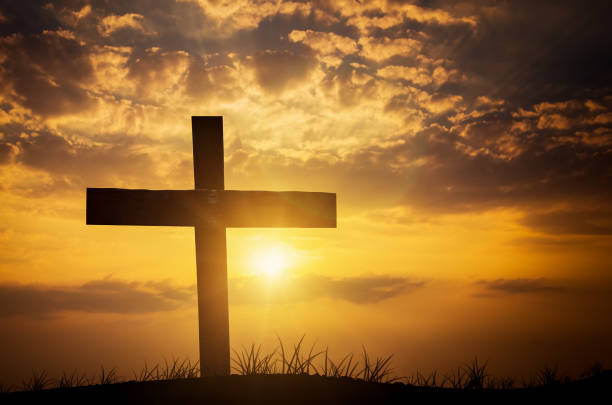 istock christian cross on sunset background 693254876