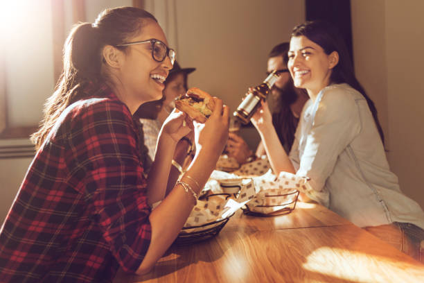 istock beautiful woman eating a burger 693255358