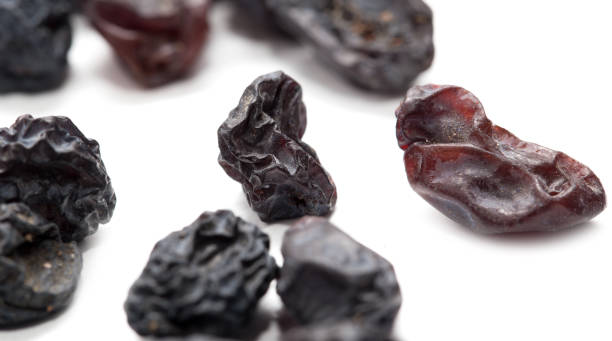 istock Black raisins on a white background. macro 693272316