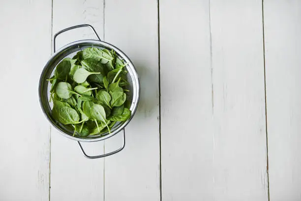 High angle shot of fresh leaves of spinach on a table