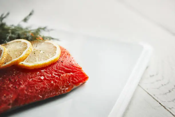 Shot of a raw piece of meat garnished with slices of lemon