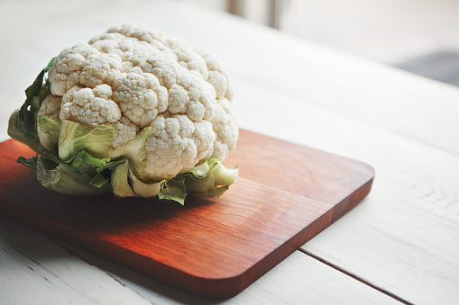 Shot of a head of cauliflower on a chopping board