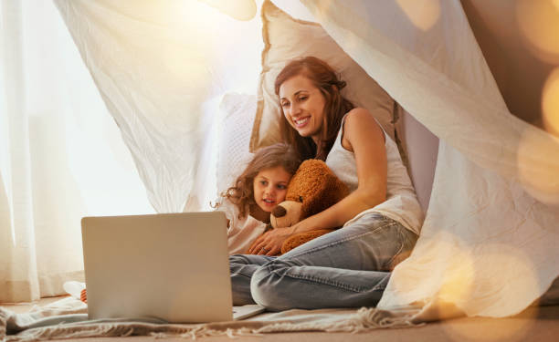 This is my favourite part Shot of a mother and daughter bonding and watching a movie on a laptop in the bedroom fort stock pictures, royalty-free photos & images