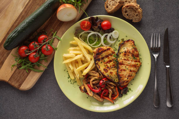 Grilled chicken breast in honey sauce and vegetables served on plate. Directly above.