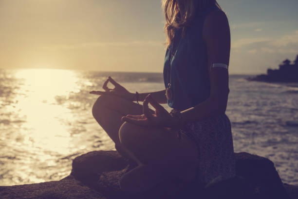 istock Woman practicing yoga on the beach. 693279702